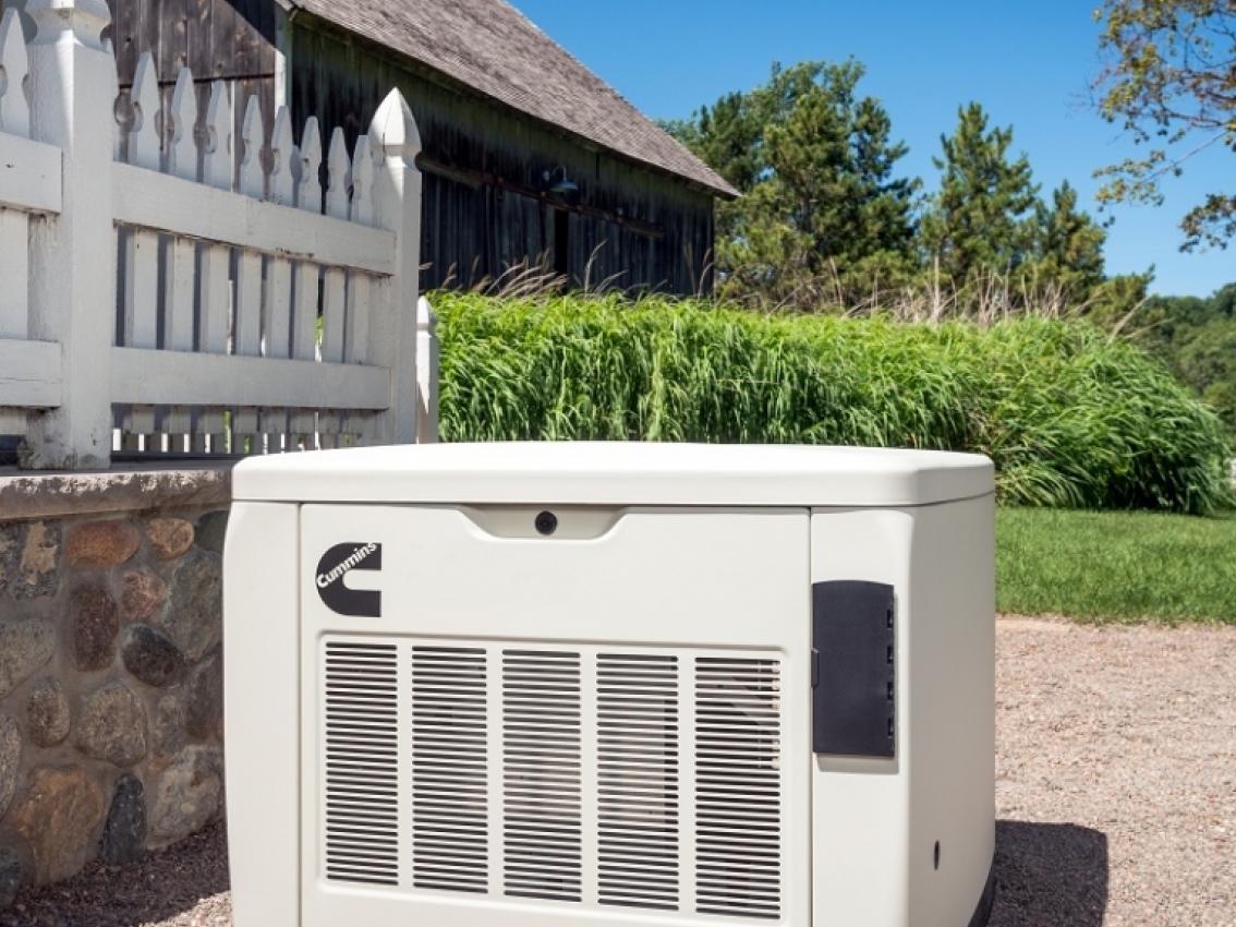 cummins-home-standby-generator-installation Technician using remote monitoring tools to manage and optimize the performance of a Cummins whole-house generator, ensuring efficient operation and safety.